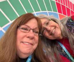 Janine Cloud and Roberta Estes smiling together at RootsTech 2025 while wearing conference badges.
