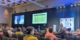 Large audience seated in a ballroom at RootsTech attending an mtDNA genealogy class presentation.