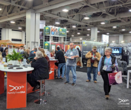 Busy RootsTech Expo Hall filled with genealogy booths, technology demonstrations, and attendees exploring new research tools.