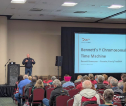 Audience seated in a large lecture hall at RootsTech listening to a genealogy class presentation.