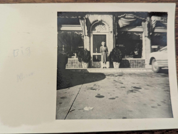 Historic photo of Gallie “Big Mama” Woods standing at the entrance of her family’s flower shop in Dallas.