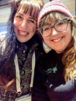 Katy Rowe-Schurwanz and Katherine Borges smiling together at a genealogy conference after discovering a distant DNA connection.